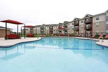 A swimming pool in front of apartment buildings.